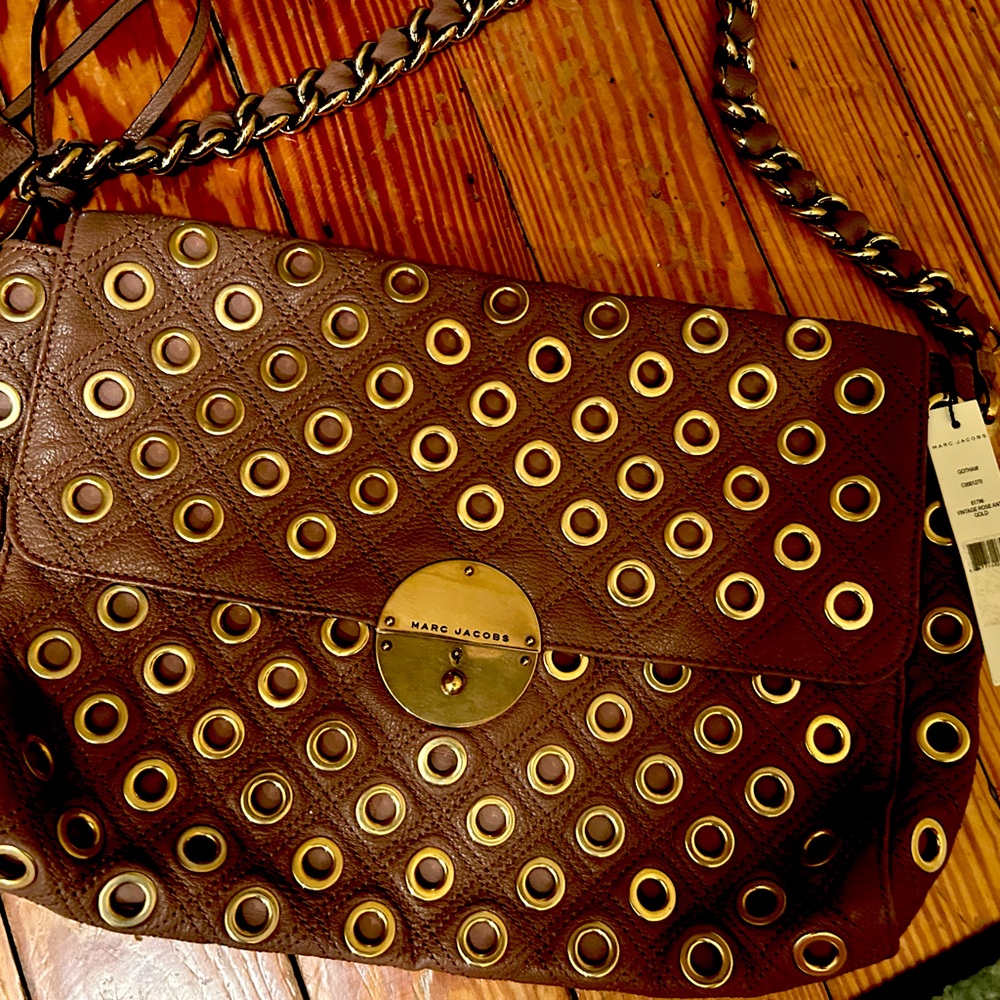 Stunning leather handbag with Gold Hardware and accents has a key to lock bag